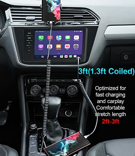 Car interior with coiled USB cable connecting smartphone to dashboard display.