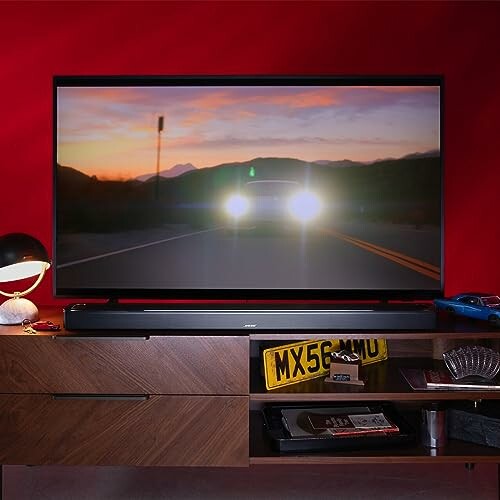 TV on wooden stand with a car scene playing