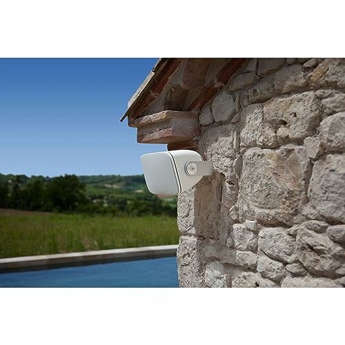 Outdoor security camera mounted on stone wall