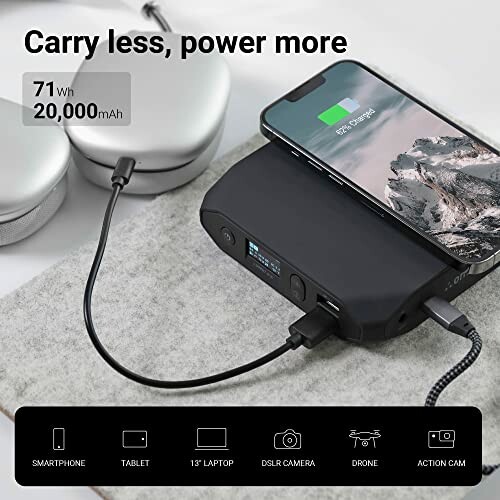 Portable power bank charging smartphone and headphones.