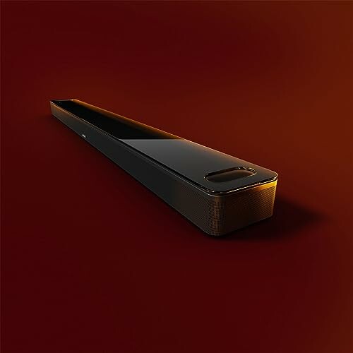 Sleek soundbar on a dark red background