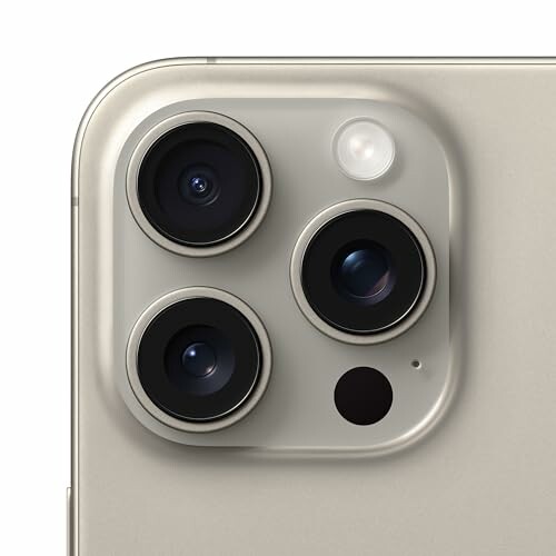 Close-up of a smartphone's rear camera module with three lenses.